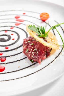 Kiraz soslu biftek ve kakule. Maydanozlu ve tohumlu lezzetli et. Beyaz tabakta servis edilen restoran yemeği. Baharatlı biftek aperatifi. Yakın çekim manzaralı. Çabuk yemek.