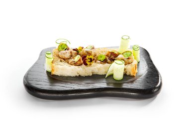 Sarımsak ve peynirli salyangoz. Soslu leziz salyangozlar. Ahşap tepside yemek tabağı. Ekmeğin üstünde menekşelerle servis edilen lezzetli bir yemek. Fransız yemek sunumu, mutfak menüsü