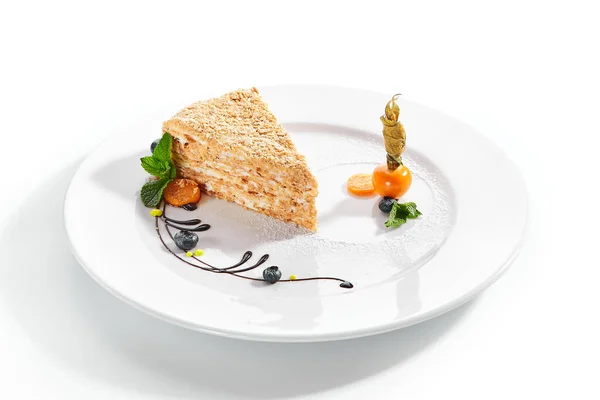 ナポレオンケーキのピース クリーム状のバニラスライスデザート ミントの葉とブルーベリーを添えておいしいペストリー 白い背景に焼きパイの層 甘い食べ物プレゼンテーション — ストック写真