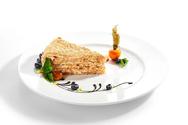 ナポレオンケーキのピース クリーム状のバニラスライスデザート ミントの葉とブルーベリーを添えておいしいペストリー 白い背景に焼きパイの層 甘い食べ物プレゼンテーション — ストック写真