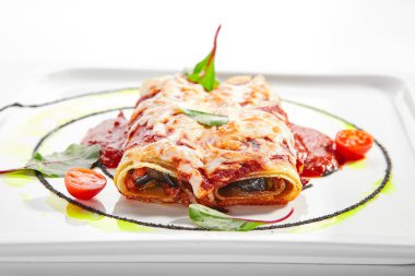 Dorblu peynirli ve domates soslu sebzeli cannelloni. Aromatik ıspanakla servis edilen rulo lazanya. Geleneksel Katalan mutfağı. Lezzetli Akdeniz yemeği yakın çekim görüntüsü. İtalyan yemeği