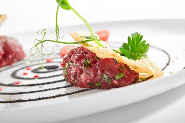 Kiraz soslu biftek ve kakule. Maydanozlu ve tohumlu lezzetli et. Beyaz tabakta servis edilen restoran yemeği. Baharatlı biftek aperatifi. Yakın çekim manzaralı. Çabuk yemek.