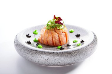 Somonlu olivier salatası. Dilimlenmiş yeşil balık yemeği. Menekşe çiçeğiyle süslenmiş lezzetli deniz ürünleri. Tabakta yemek var. Restoran yemeği, zarif yemek kompozisyonu.