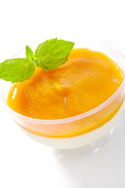 Beyaz arka planda meyveli panna cotta tatlı, tatlı krema ve jelatin. Lezzetli jöleli krema ya da taze nane yapraklarıyla dekore edilmiş cam panacotta.