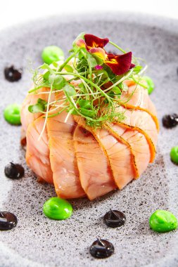 Somonlu olivier salatası. Dilimlenmiş yeşil balık yemeği. Menekşe çiçeğiyle süslenmiş lezzetli deniz ürünleri. Tabaklara yakın çekim mutfağı. Restoran yemeği, zarif yemek kompozisyonu.