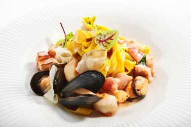 Deniz mahsulleri manzaralı Tagliatelle makarnası. Geleneksel İtalyan yemekleri, karides ve midye. Kremalı soslu lezzetli yemek ve tabakta yeşillik. Mutfak kompozisyonu, yemek sunumu