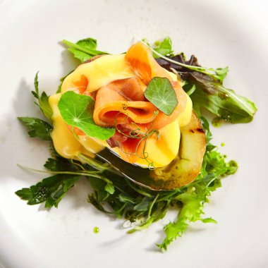 Yumurta ve somon balıklı fırında patates. Yeşillik ve sebzeli lezzetli balıklar. Beyaz tabakta soslu lezzetli deniz ürünleri. Yemek servisi, yemek kompozisyonu. Aşçılık sunumu