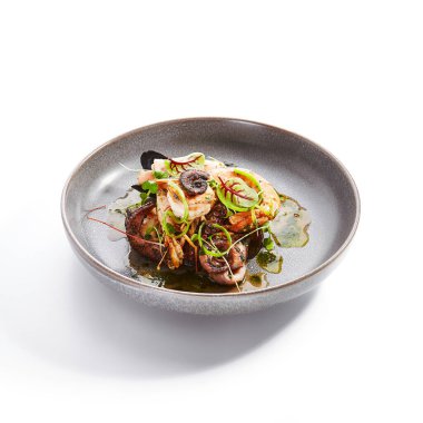 Çeşitli deniz ürünleri yan manzarası. Ahtapot, karides ve istiridye. Lezzetli karidesler ve tabakta yeşillik. Lezzetli bir restoran lezzeti. Kızarmış Asya yemeği. Yemek kompozisyonu, aşçılık sunumu