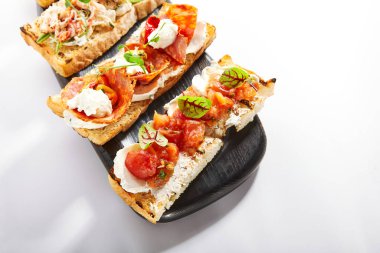 Fırında domatesle yakin görüntü. Peynirli ve sebzeli Aromatik atıştırmalıklar. Geleneksel antipasto, başlangıç yemeği. İtalyan mutfağı, sebzeli gevrek aperatifler.