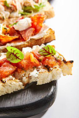 Fırında domatesle yakin görüntü. Peynirli ve sebzeli Aromatik atıştırmalıklar. Geleneksel antipasto, başlangıç yemeği. İtalyan mutfağı, sebzeli gevrek aperatifler.