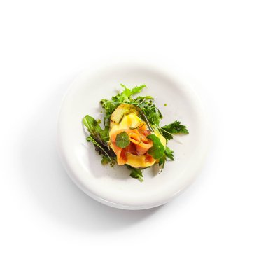 Yumurta ve somon balıklı fırında patates. Yeşillik ve sebzeli lezzetli balıklar. Beyaz tabakta soslu lezzetli deniz ürünleri. Yemek servisi, yemek kompozisyonu. Aşçılık sunumu