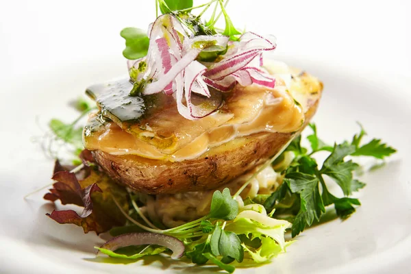 Baked potato with egg and pickled onion. Aromatic dish with green parsley closeup view. Cut vegetables with sauce on white plate. Restaurant food composition, culinary presentation