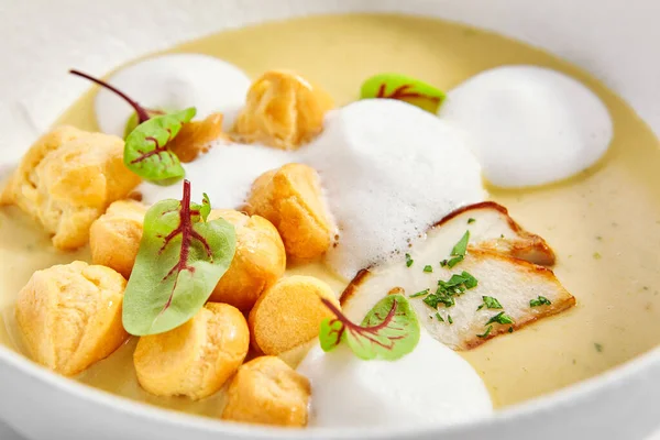 野生キノコクリームスープチーズプロフィテロール付き 白いボウルに緑と芳香族料理 美味しい食事をお楽しみいただけます ヨーロッパ料理 料理のプレゼンテーション レストランの珍味 — ストック写真