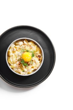 Fırınlanmış carbonara üst görünümü. Yumurtalı makarna, peynir ve taze yeşillik. Geleneksel İtalyan yemeği. Lezzetli yemek kompozisyonu, mutfak sunumu. Avrupa mutfağı, lezzetli servis edilen yemekler.
