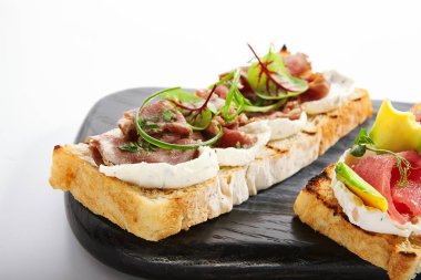 Pastırma soslu, yakın plan manzaralı Etli ve yeşillikli İtalyan atıştırması. Sığır etli baget. Geleneksel antipasto, lezzetli başlangıç yemeği. Yemek kompozisyonu, aşçılık sunumu