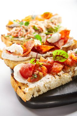 Deniz mahsulleri ve sebzeler. Somon, yengeç ve salatalıkla başlayın. Sucuklu aperatifler, burrata ve fırında domates. Yemek kompozisyonu, lezzetli İtalyan yemeği.