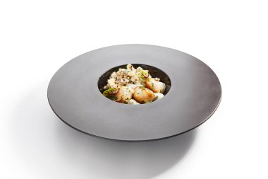 Yeşil karabuğday kenarlı deniz tarağı. Yeşillik ve peynirle servis edilen lezzetli deniz ürünleri. Deniz lezzeti, aromatik soslu pişirilmiş yumuşakça. Yemek kompozisyonu, haute cuisine. Restoran yemeği.