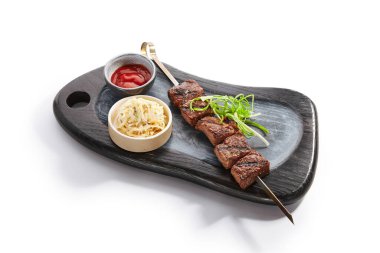 Mermer sığır şişi yan görünüş. Sos ve ahşap tepside şehriye ile nefis kebap. Lezzetli garnitürlü ızgara et. Soğanlı baharatlı yemek. Yenge yemeği, kızarmış yemek kompozisyonu.