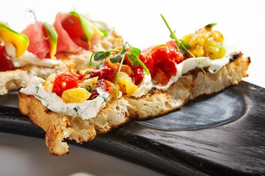 Fırında biberle yakin bir manzara. Sebzeli ve yeşillikli nefis kızarmış ekmek. Peynirli geleneksel İtalyan atıştırması. Ahşap tepside nefis bir yemek. Mutfak kompozisyonu