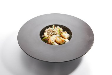 Yeşil karabuğday kenarlı deniz tarağı. Yeşillik ve peynirle servis edilen lezzetli deniz ürünleri. Deniz lezzeti, aromatik soslu pişirilmiş yumuşakça. Yemek kompozisyonu, haute cuisine. Restoran yemeği.