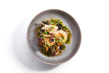 Deniz ürünleri çeşitli yakın çekim manzarası. Ahtapot, karides ve istiridye. Lezzetli karidesler ve tabakta yeşillik. Lezzetli bir restoran lezzeti. Kızarmış Asya yemeği. Yemek kompozisyonu, aşçılık sunumu