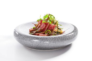 Tataki ton balığı yan görüntüsü. Geleneksel Japon mutfağı metodu. Tabakta lezzetli balıklar var. Yeşillik ve baharatlı dilimlenmiş deniz ürünleri. Asya mutfağı, yemek kompozisyonu. Restoran yemeği.