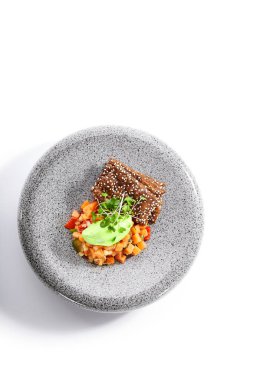 Somon tartare en iyi manzara. Baharatlı çiğ kırmızı balık ve tabakta kraker. Ekmek dilimleriyle taze ton balığı servis ettim. Şifalı otlarla süslenmiş deniz ürünleri restoranı yemekleri. Deniz lezzeti, gurme yemeği.