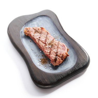 Bifteği tuz ve baharatla soyun. Kızarmış et yakın çekim görüntüsü. Tabakta ızgara et. Lokanta lezzetli yemekler. Barbekü yemeği, gurme yemeği. Barbekü domuz eti. Kızarmış fileto, inek filetosu.