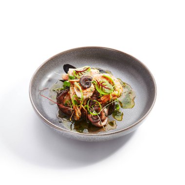 Çeşitli deniz ürünleri yan manzarası. Ahtapot, karides ve istiridye. Lezzetli karidesler ve tabakta yeşillik. Lezzetli bir restoran lezzeti. Kızarmış Asya yemeği. Yemek kompozisyonu, aşçılık sunumu