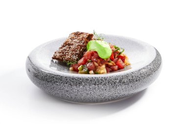 Ton balığının yan görüntüsü. Baharatlı doğranmış balık ve kraker. Yeşillik, sebze ve ekmekle lezzetli deniz ürünleri. Haute food, lezzetli restoran yemekleri. Yemek kompozisyonu, yemek tarifi.