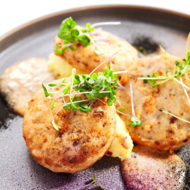 Bahçe teresi manzaralı balık köfteleri. Tepside yeşillik olan lezzetli fileto balıklar. Kokulu soslu kroket deniz ürünleri. Restoran yemeği, aşçılık sunumu. Yiyecek bileşimi