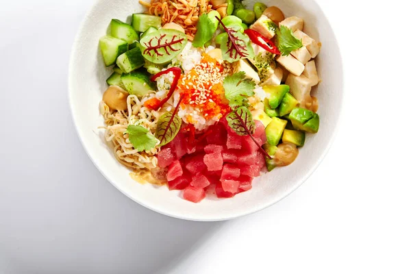 Poke with tuna and noodles. Hawaiian salad with avocado and tofu top view. Traditional polynesian dish with rice and cheese. Delicious native cuisine. Meal served with edamame, vegetables and soybean