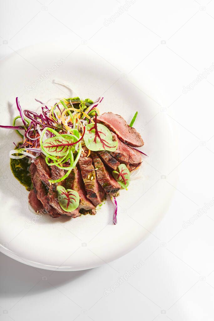 Tataki roast beef top view. Tasty grilled meat with onion and greenery. National cuisine, traditional asian recipe. Japanese culinary method. Delicious meal with sauce and seasonings