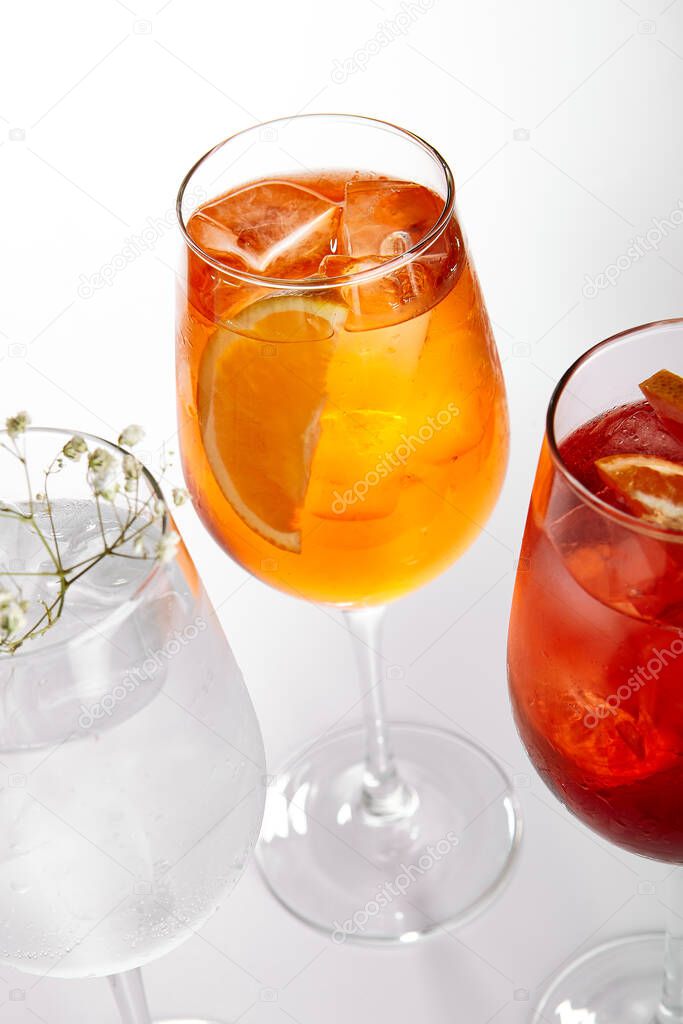 Spritz fruit cocktails. Alcohol soft drinks in glasses side view. Refreshment beverage with coconut, berry, orange in drinkware. Exotic summer beach cocktail portions with crushed ice in glassware