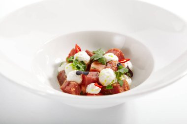 Stracciatella peynirli ve baharatlı soslu ton balığı. Taze yeşil maydanozlu deniz ürünleri. Beyaz arka planda yeşilliği olan lezzetli balıklar. Lezzetli restoran yemekleri. Mutfak kompozisyonu