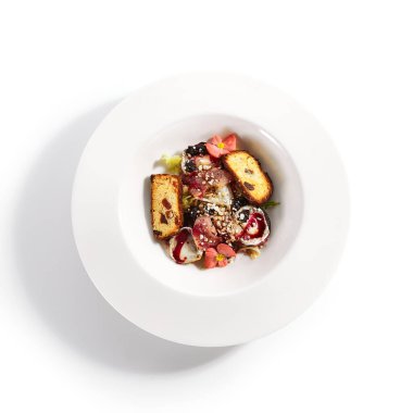 Böğürtlen soslu armut buğulama. Fransız keçi peyniri ve brioche ile besin kompozisyonu. Tabakta çiçeklerle servis edilen haute yemek tabağı. Beyaz masada nefis bir fırın yemeği.