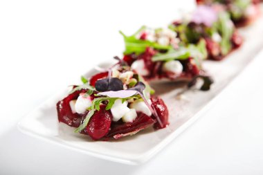 Tepside keçi peynirli pancar tartı. Roka ve baharatlı lezzetli atıştırmalıklar. Mutfağa koşun. Restoran sebze aperatifleri taze yeşillikle servis ediliyor. Yemek sunumu, aşçılık tarifi