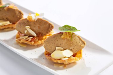 Çilek soslu hindi ciğeri ezmesi. Yeşillik ve çiçeklerle servis edilen etli aperatifler. Uzun beyaz tabakta lezzetli Fransız mutfağı. Şuruplu lezzetli mezeler.