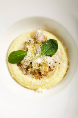 Tavuk yahnisi. Güveç, sebze ve et. İtalyan geleneksel mutfağı. İtalyan restoranının yemek bölümü, beyaz tabakta ana yemek. Orman mantarı ve mantar yağlı buharda pişirilmiş yemek.