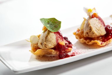 Böğürtlen soslu hindi ciğeri ezmesi. Yeşillik ve çiçeklerle servis edilen etli aperatifler. Uzun beyaz tabakta lezzetli Fransız mutfağı. Şuruplu lezzetli mezeler.