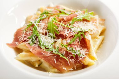 Parmesan soslu makarna. Geleneksel İtalyan mutfağı servis edildi. Prosciutto, trüf yağı ve roka yapraklı makarna. İtalyan mutfağı. Restoran yemek bölümü, ana yemek, kapatın.