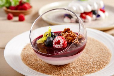 Böğürtlenli Panna Cotta ve cam kasede Currant-Cointreau jölesi. Böğürtlenli kremalı tatlı. Tatlı yemek, ahududu ve kuşüzümlü sufle. Gurme aperatifler, lezzetli restoran yemekleri.