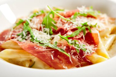 Parmesan soslu makarna. Geleneksel İtalyan mutfağı servis edildi. Prosciutto, trüf yağı ve roka yapraklı makarna. İtalyan mutfağı. Restoran yemek bölümü, ana yemek, kapatın.