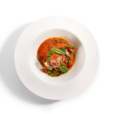 Halibut bifteği ve çıtır ekmek. Mutfak servisi. Balık filetosu ve beyaz tabakta domates soslu kabaklı spagetti. Restoran yemekleri, lezzetli yemekler, ana yemek.