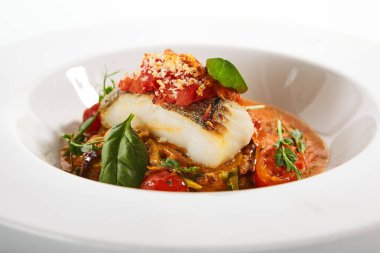 Halibut bifteği ve çıtır ekmek. Mutfak servisi. Balık filetosu ve beyaz tabakta domates soslu kabaklı spagetti. Restoran yemekleri, lezzetli yemekler, ana yemek.