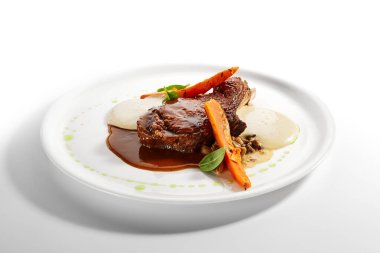 Kemiğe sığır filetosu yakın çekim. Kızarmış et, fırında patates ve mantar yahnisi. Gurme aşçılık, gastronomi. Restoran yemekleri, ana yemek.