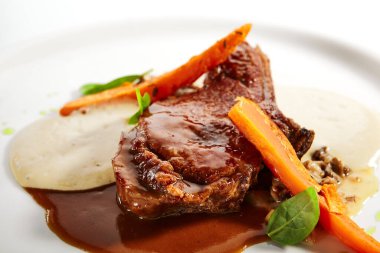 Kemiğe sığır filetosu yakın çekim. Kızarmış et, fırında patates ve mantar yahnisi. Gurme aşçılık, gastronomi. Restoran yemekleri, ana yemek.