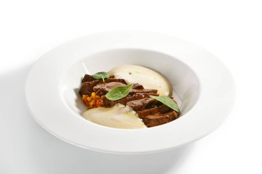 Sığır kalbi yahnisi ve sebzeler. Kızarmış et ve sebzeli risotto beyaz arka planda izole edilmiş tabakta servis edildi. Gurme aşçılık, gastronomi. Restoran yemekleri, ana yemek.