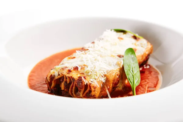 ラザニアのボロネーゼを閉じます 伝統的なイタリア料理を提供します パスタ トマトソース すりおろしたチーズとバジルの葉で料理をプレートに残します イタリア料理 飲食部 メインコース — ストック写真