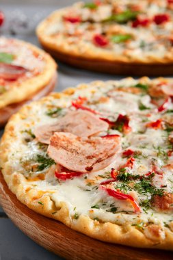 Tahtada etli pizza. Jambonlu, tavuklu, salamlı, domatesli, dolma biberli, mozzarellalı ve beyaz soslu fırın. Geleneksel İtalyan yemekleri, servis edilen restoran yemekleri, sıcak atıştırmalıklar.